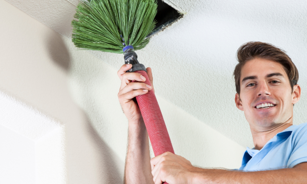 Air conditioning vent cleaning technician inserting cleaning probe into vent.